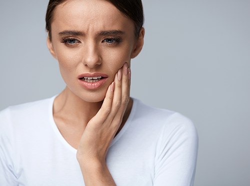 woman holding her jaw showing pain