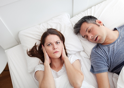 woman irritated with man snoring